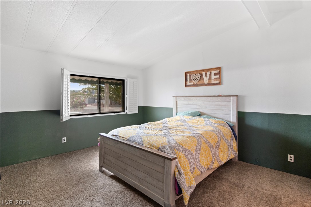 1655 Granada Street Laughlin, NV 89029 - Photo 24 of 76 Primary Bedroom with lofted ceiling with beams and carpet floors