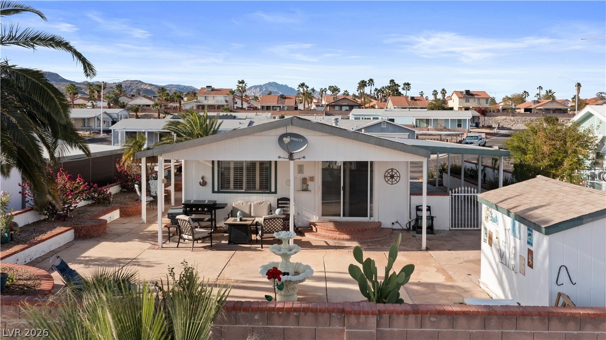 1655 Granada Street Laughlin, NV 89029 - Photo 56 of 76 Rear view of property with a patio area, a residential view, an outdoor hangout area, and a mountain view