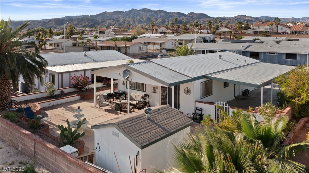1655 Granada Street Laughlin, NV 89029 - Photo 59 of 76 Back of house with an outdoor lounge area, a patio, a metal roof, a mountain view, and a residential view