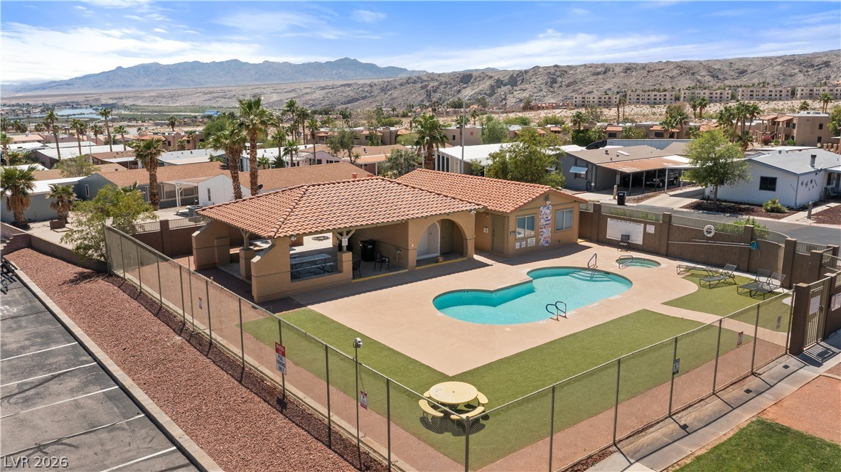 1655 Granada Street Laughlin, NV 89029 - Photo 71 of 76 Monte Del Sol community pool, hot tub spa, pool shower, and covered patio and surrounding artificial turf grass area