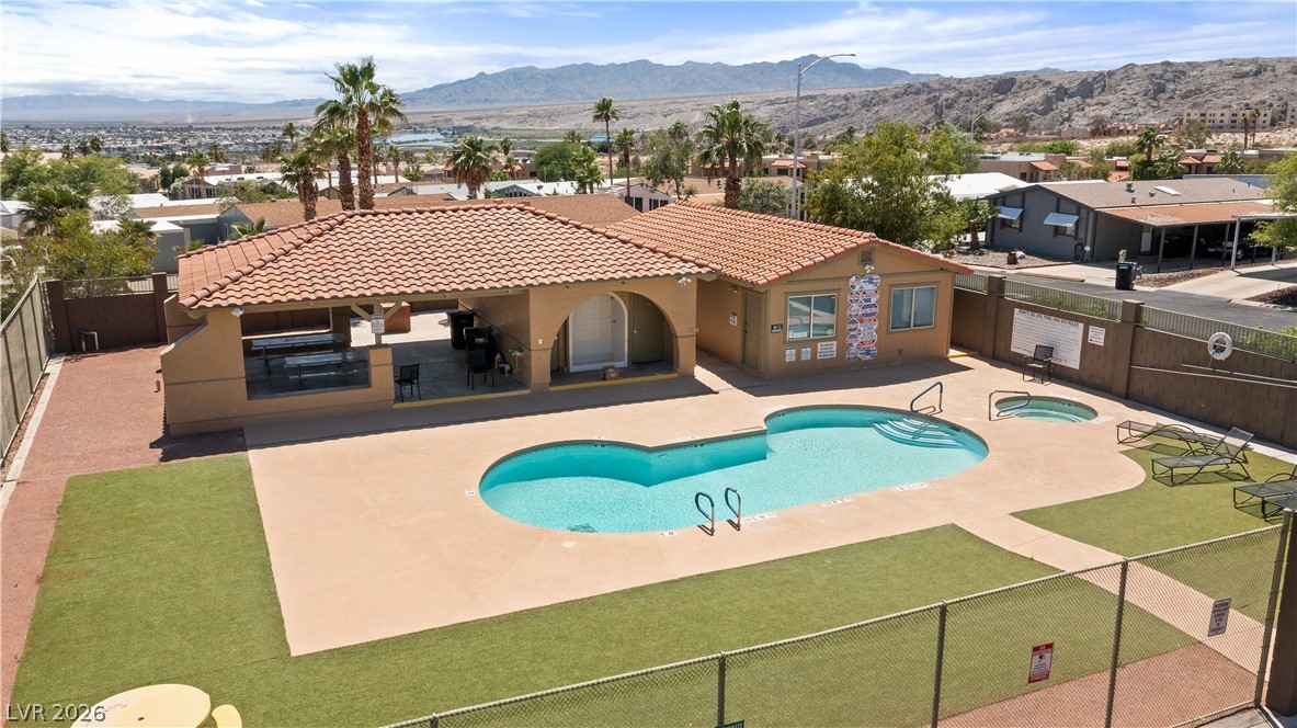 1655 Granada Street Laughlin, NV 89029 - Photo 72 of 76 Monte Del Sol community pool, hot tub spa, pool shower, and covered patio and surrounding artificial turf grass area