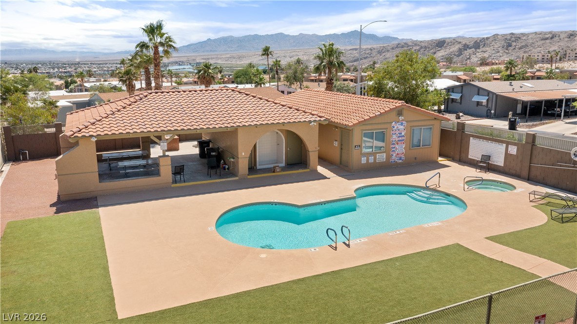 1655 Granada Street Laughlin, NV 89029 - Photo 73 of 76 Monte Del Sol community pool, hot tub spa, pool shower, and covered patio and surrounding artificial turf grass area