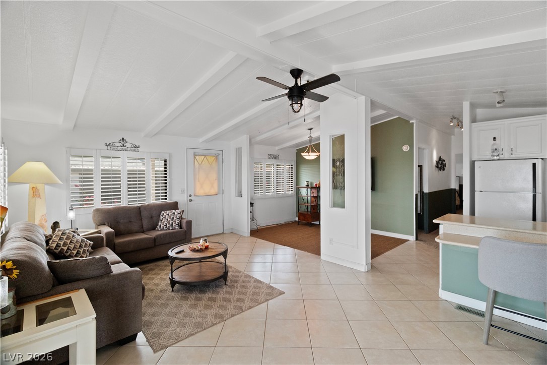 1655 Granada Street Laughlin, NV 89029 - Photo 8 of 76 Living area featuring light tile patterned floors, a ceiling fan, and lofted ceiling with beams
