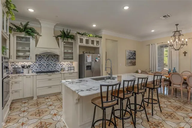 a kitchen with stainless steel appliances kitchen island granite countertop a table and chairs in it