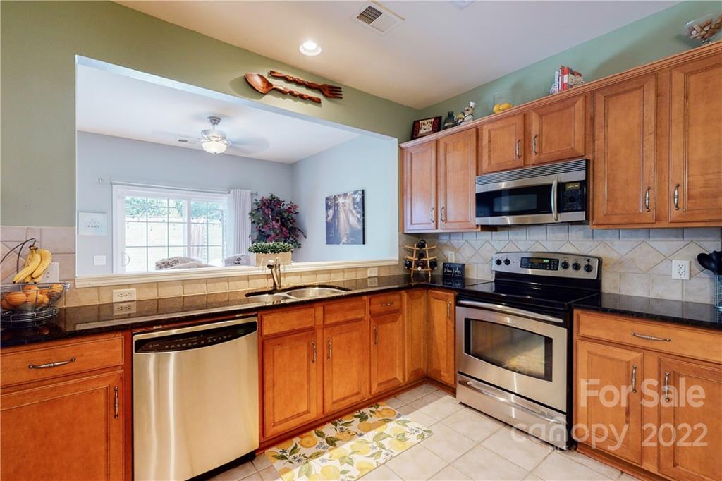 9136 Redmond Trace Road Charlotte, NC 28277 - Photo 14 of 37 a kitchen with stainless steel appliances a stove sink microwave and cabinets