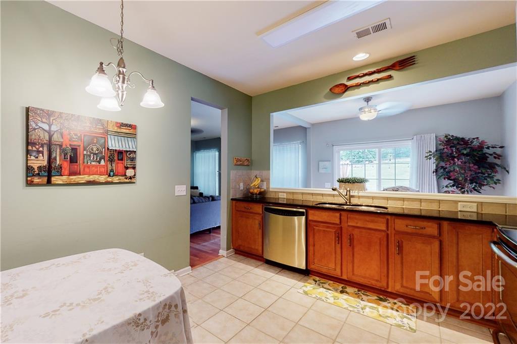 9136 Redmond Trace Road Charlotte, NC 28277 - Photo 17 of 37 a kitchen with stainless steel appliances granite countertop a sink and wooden floor