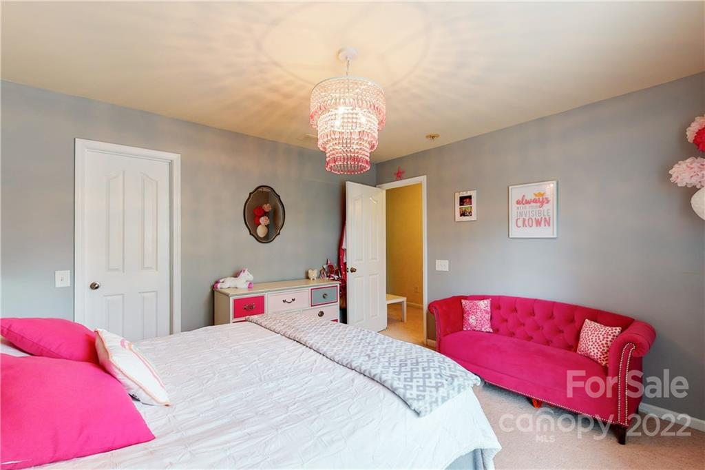 9136 Redmond Trace Road Charlotte, NC 28277 - Photo 26 of 37 a bedroom with a bed and a chandelier