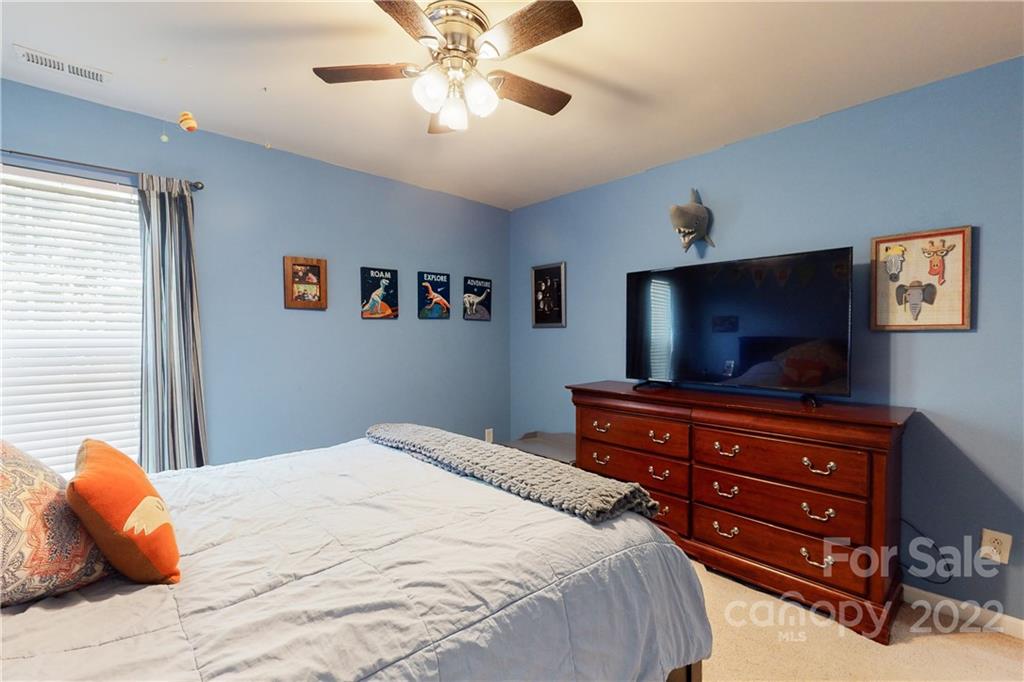 9136 Redmond Trace Road Charlotte, NC 28277 - Photo 30 of 37 a bedroom with a bed and a chandelier