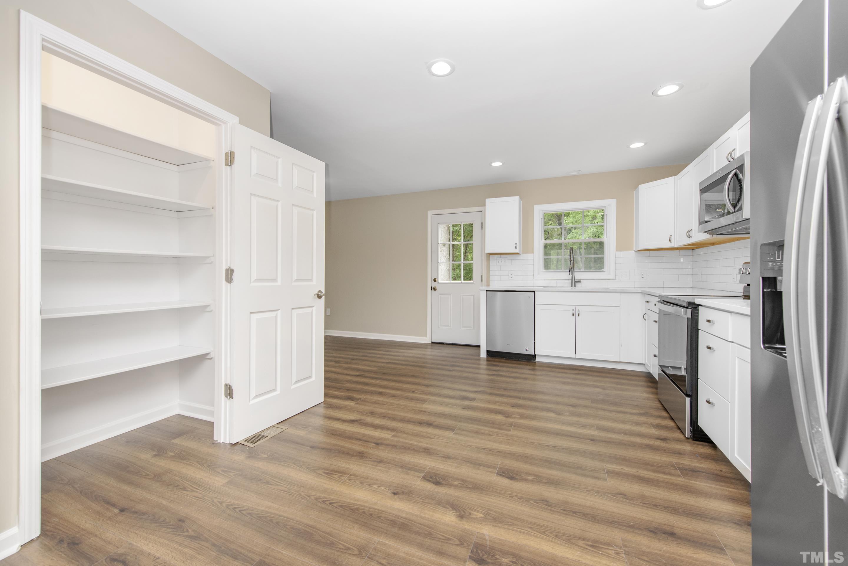 212 Junction Road Durham, NC 27703 - Photo 9 of 50 a view of a kitchen with wooden floor and electronic appliances