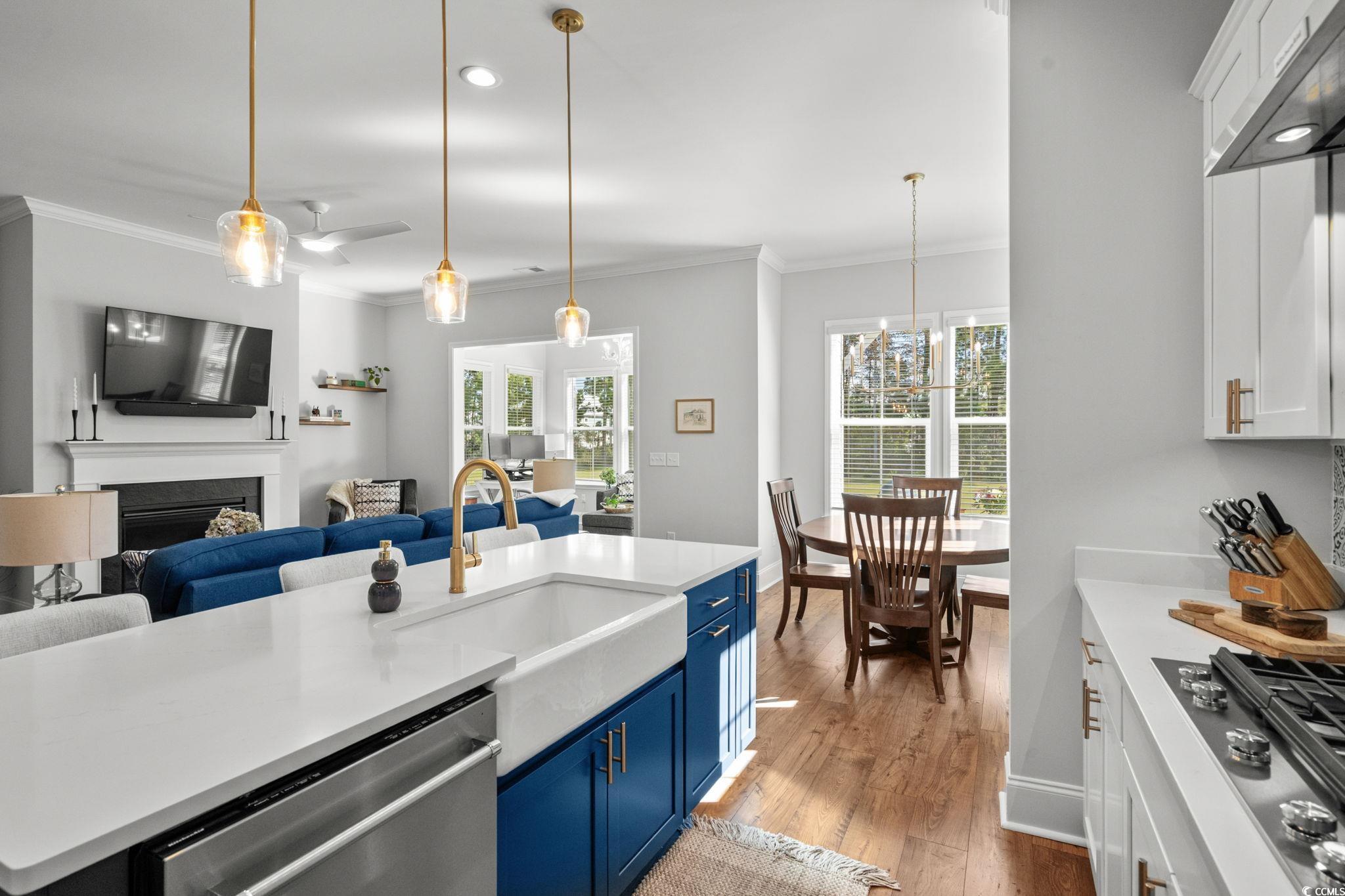 191 Blackwater Drive Murrells Inlet, SC 29576 - Photo 40 of 40 Kitchen featuring blue cabinetry, white cabinets, open floor plan, appliances with stainless steel finishes, and ornamental molding
