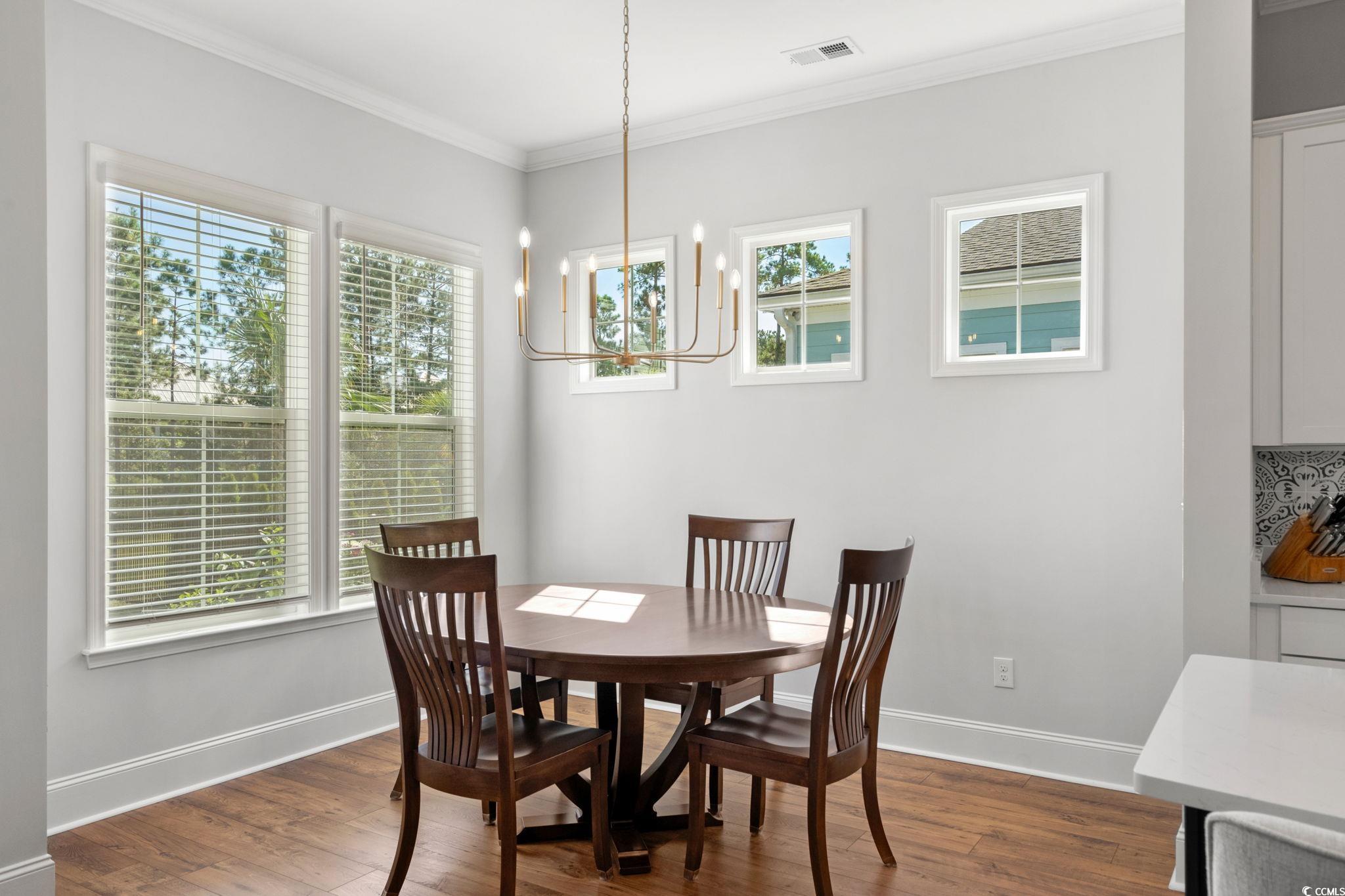 191 Blackwater Drive Murrells Inlet, SC 29576 - Photo 12 of 40 Dining area featuring dark wood finished floors, crown molding, and a chandelier