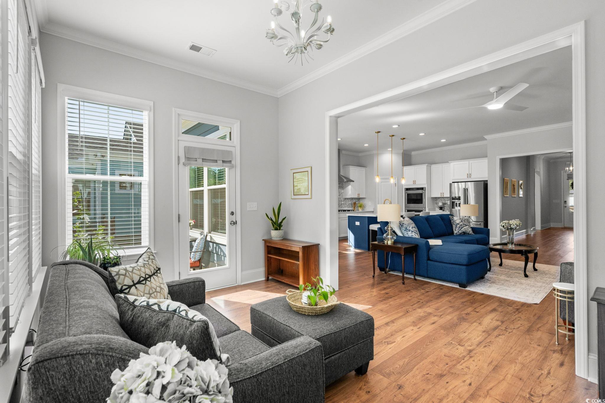 191 Blackwater Drive Murrells Inlet, SC 29576 - Photo 14 of 40 Living area featuring ornamental molding, a chandelier, light wood finished floors, and ceiling fan