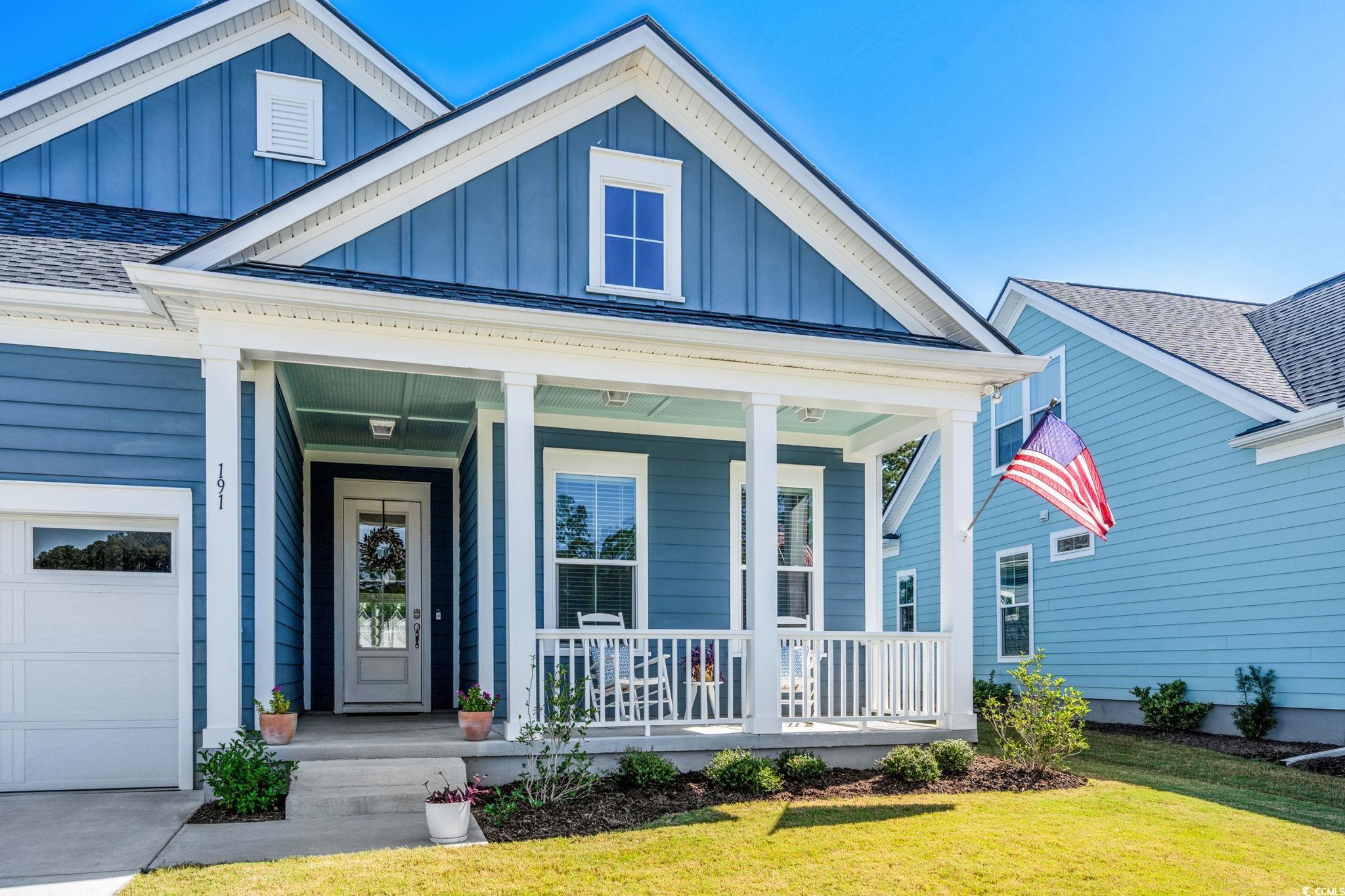 191 Blackwater Drive Murrells Inlet, SC 29576 - Photo 2 of 40 View of front facade featuring board and batten siding, a porch, a shingled roof, and a front lawn