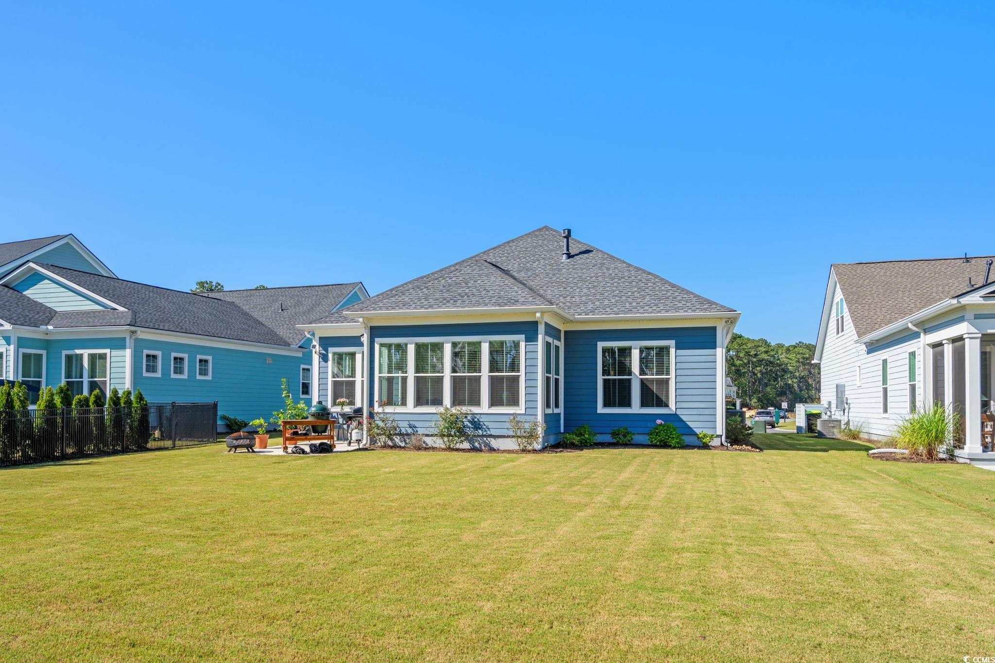 191 Blackwater Drive Murrells Inlet, SC 29576 - Photo 32 of 40 Back of property with a lawn, a patio area, and roof with shingles