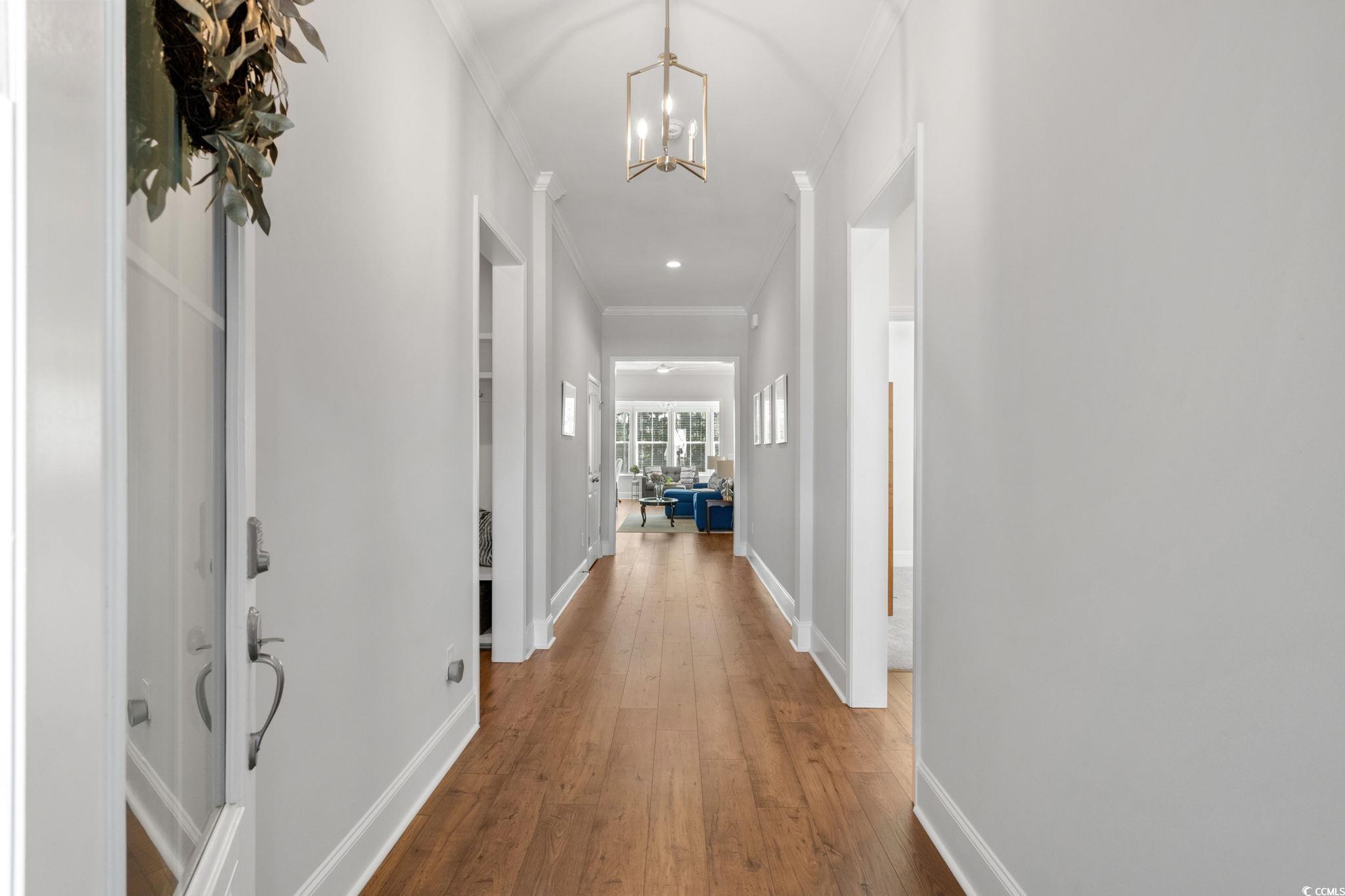 191 Blackwater Drive Murrells Inlet, SC 29576 - Photo 4 of 40 Hallway with hardwood / wood-style floors, crown molding, and a chandelier