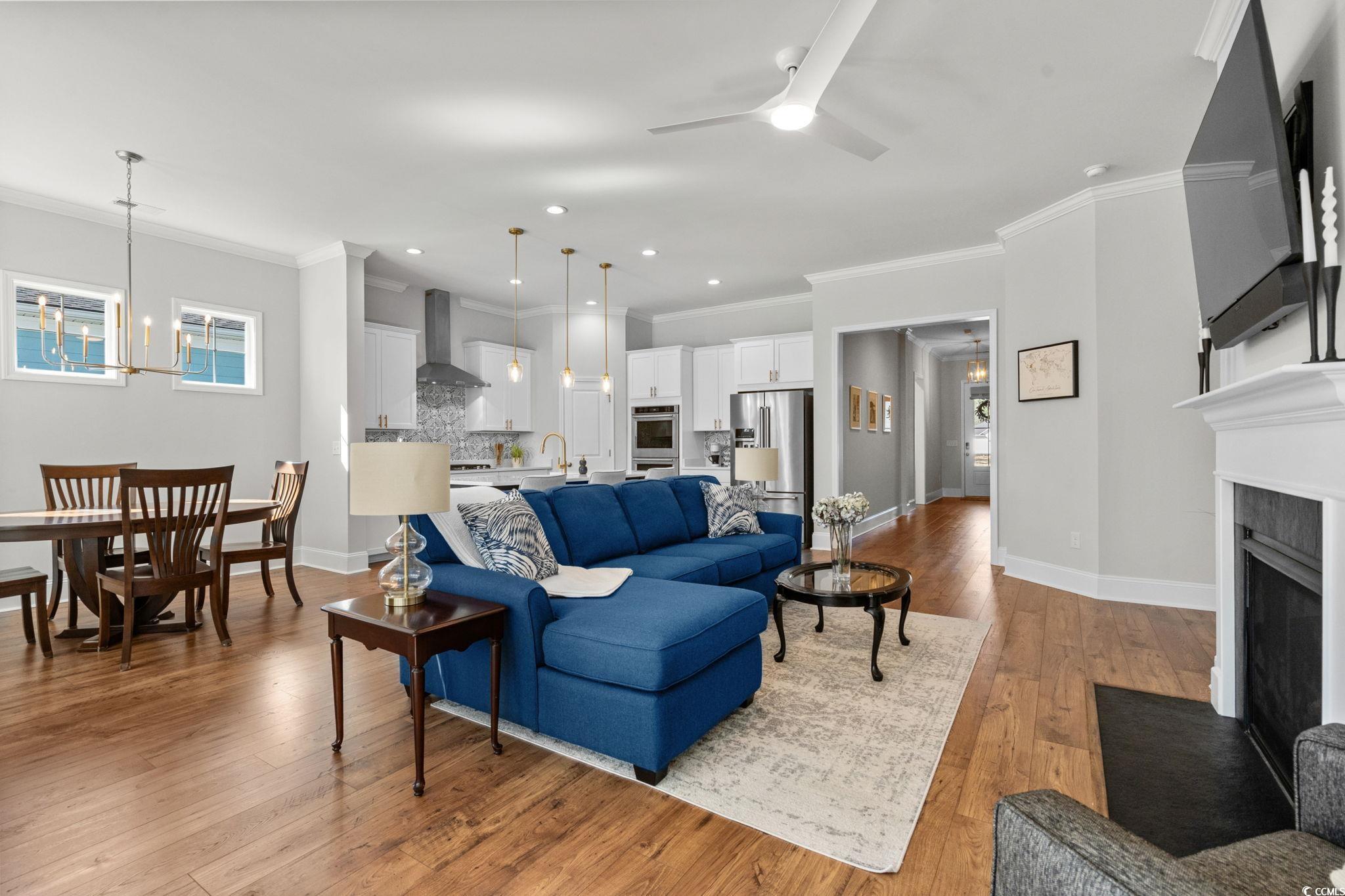 191 Blackwater Drive Murrells Inlet, SC 29576 - Photo 6 of 40 Living area featuring ornamental molding, light wood-style floors, a ceiling fan, a fireplace with flush hearth, and recessed lighting
