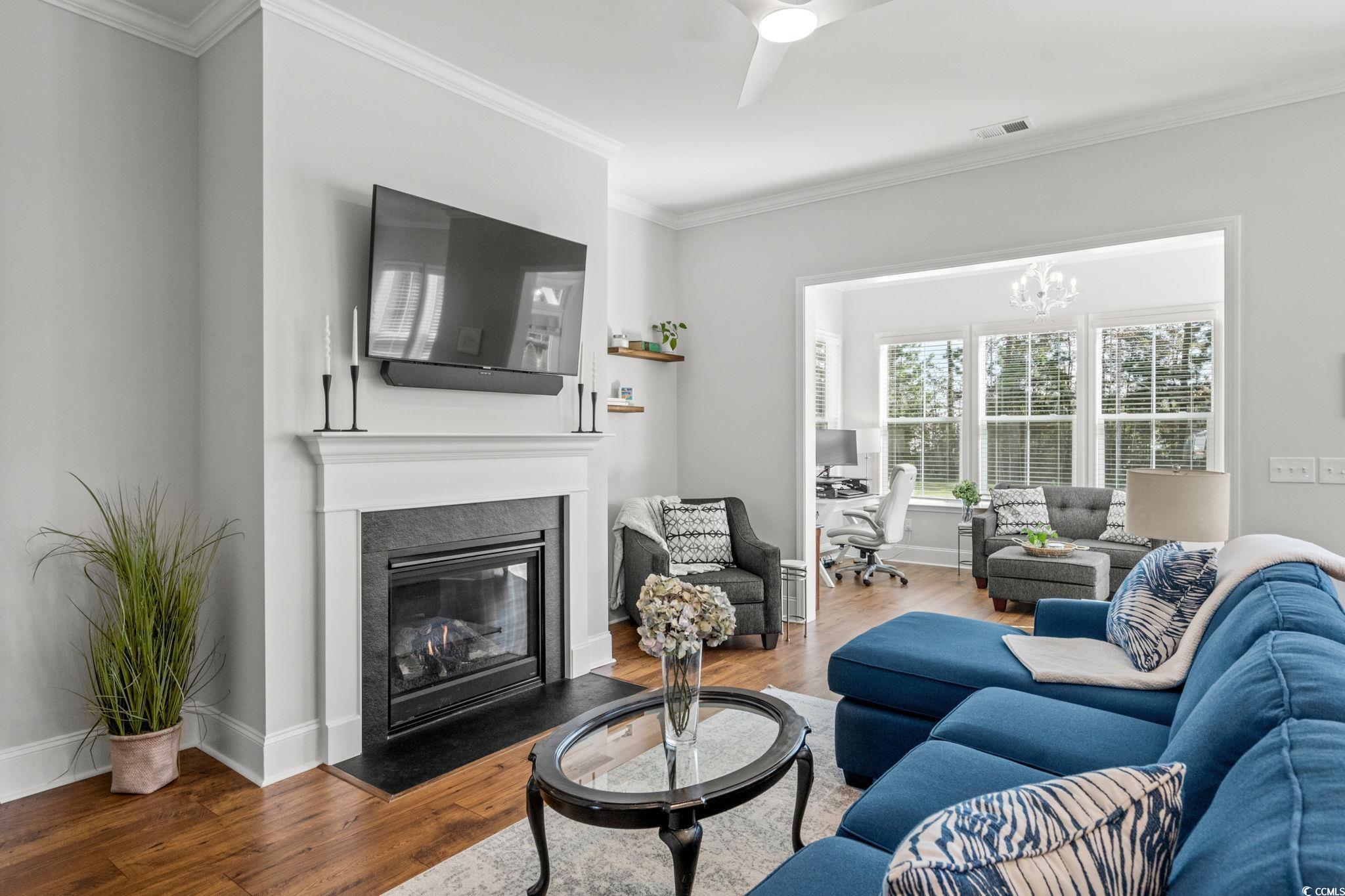 191 Blackwater Drive Murrells Inlet, SC 29576 - Photo 7 of 40 Living room featuring ornamental molding, wood finished floors, a desk, a fireplace with flush hearth, and ceiling fan