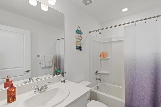 a bathroom with a sink a mirror a shower and a bathtub