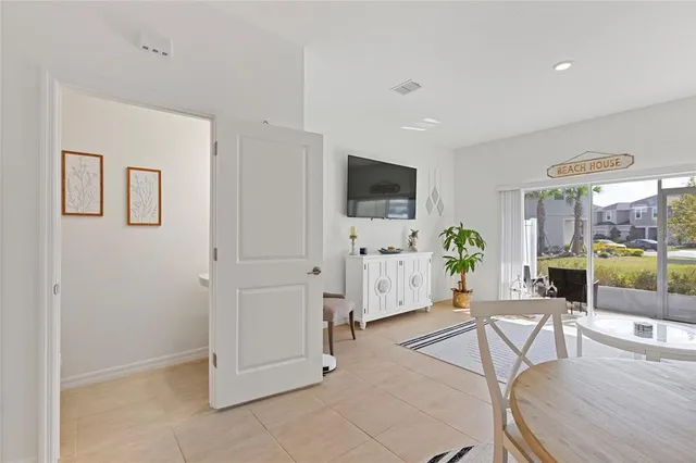a living room with furniture a flat screen tv and a view of kitchen
