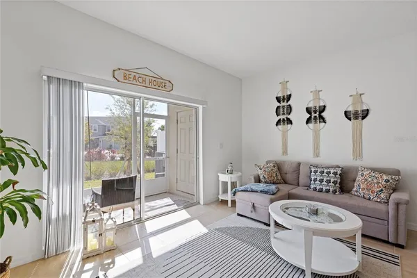 a living room with furniture and a floor to ceiling window