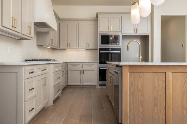 a kitchen with white cabinets appliances and sink