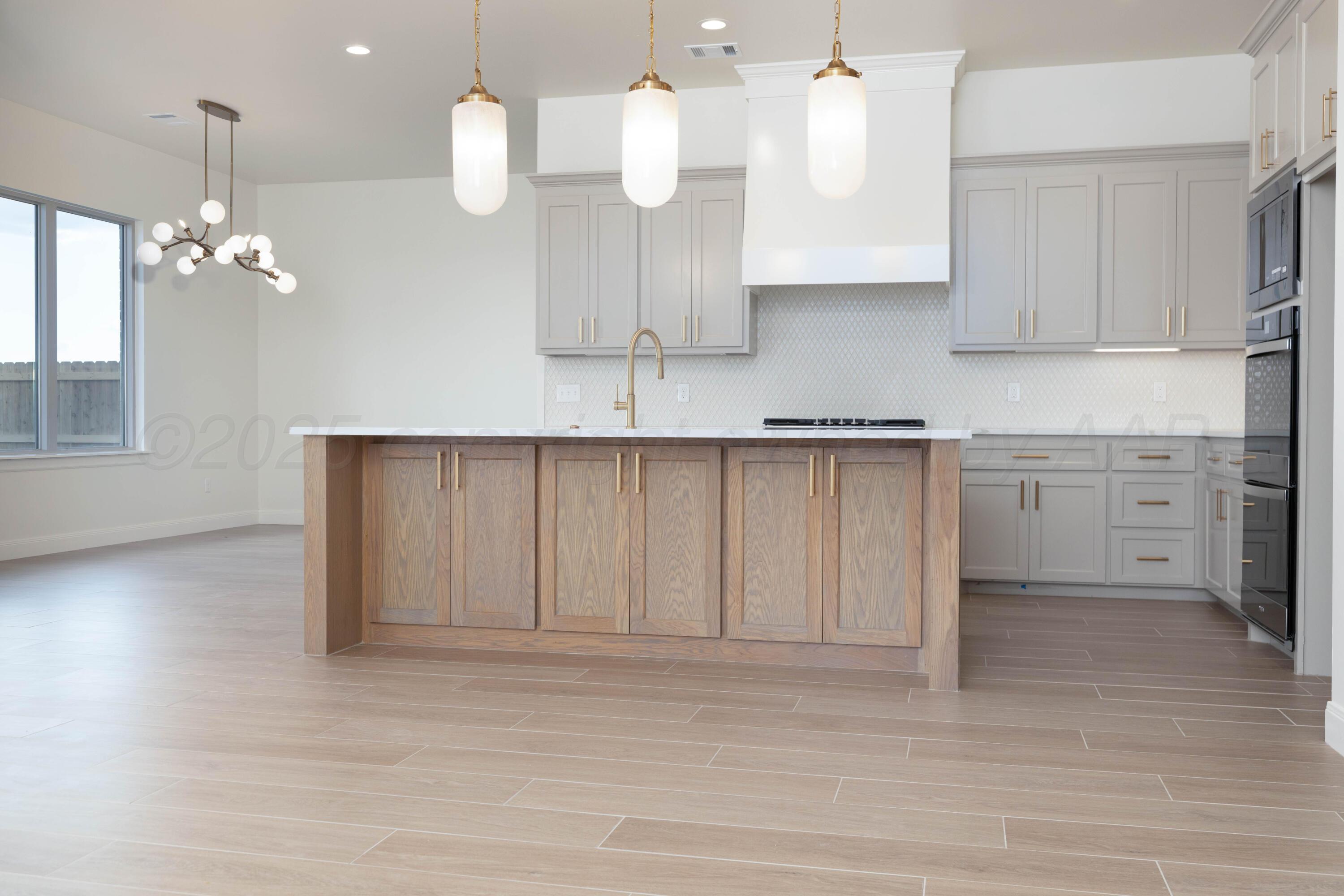 10251 Prickly Pear Road Amarillo, TX 79119 - Photo 15 of 30 a kitchen with a sink chandelier and wooden cabinets