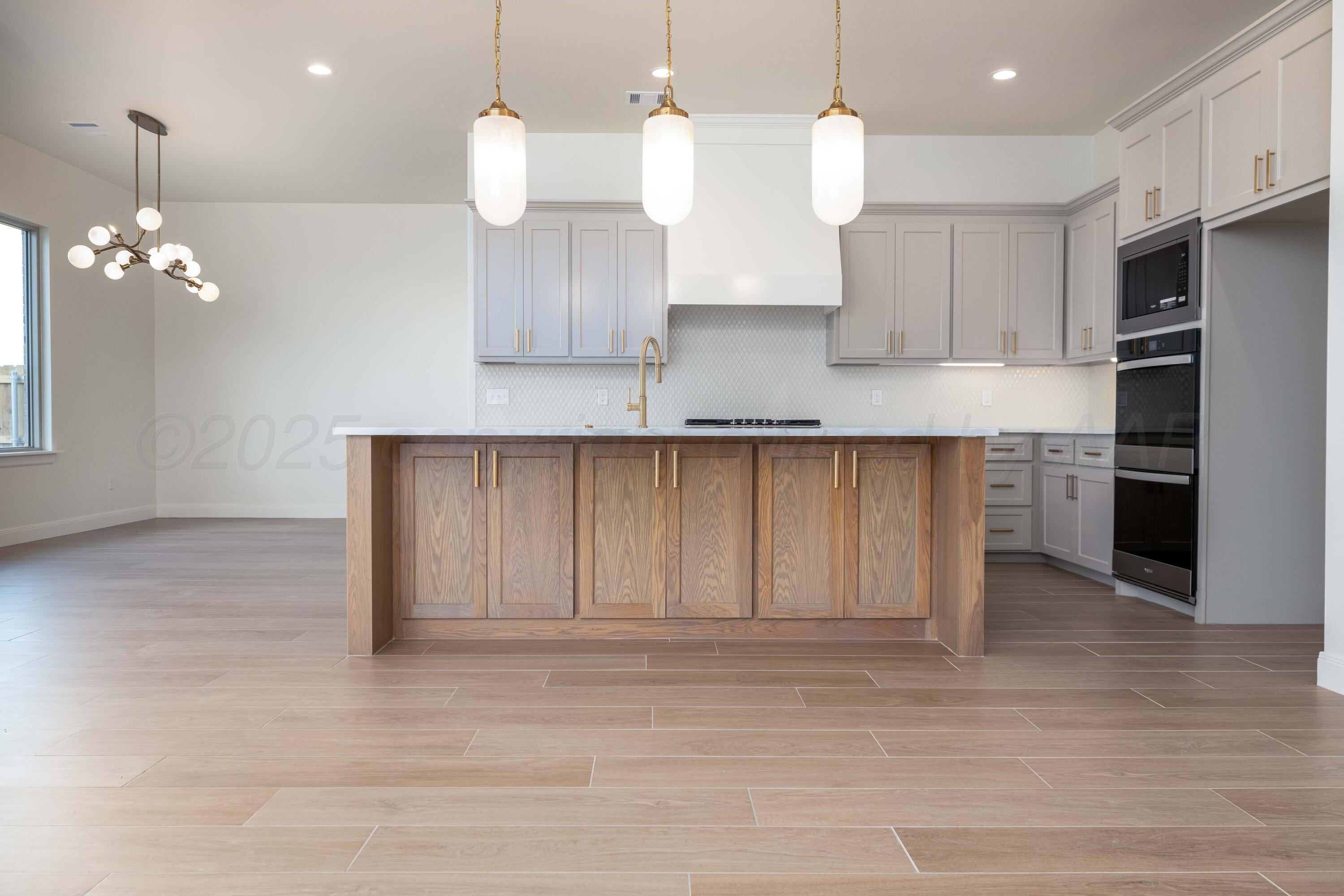 10251 Prickly Pear Road Amarillo, TX 79119 - Photo 18 of 30 a kitchen with kitchen island white cabinets and stainless steel appliances