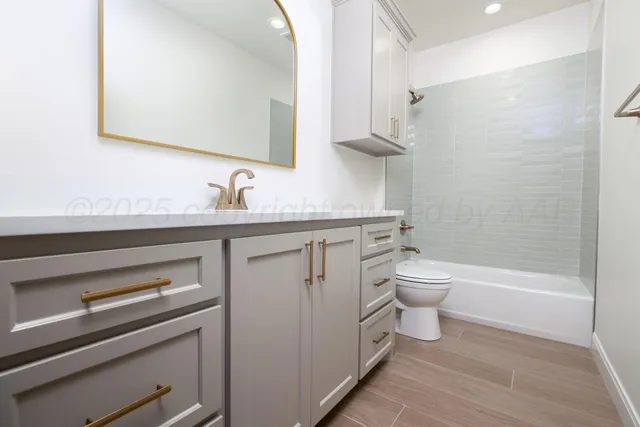 a bathroom with a granite countertop toilet sink and mirror