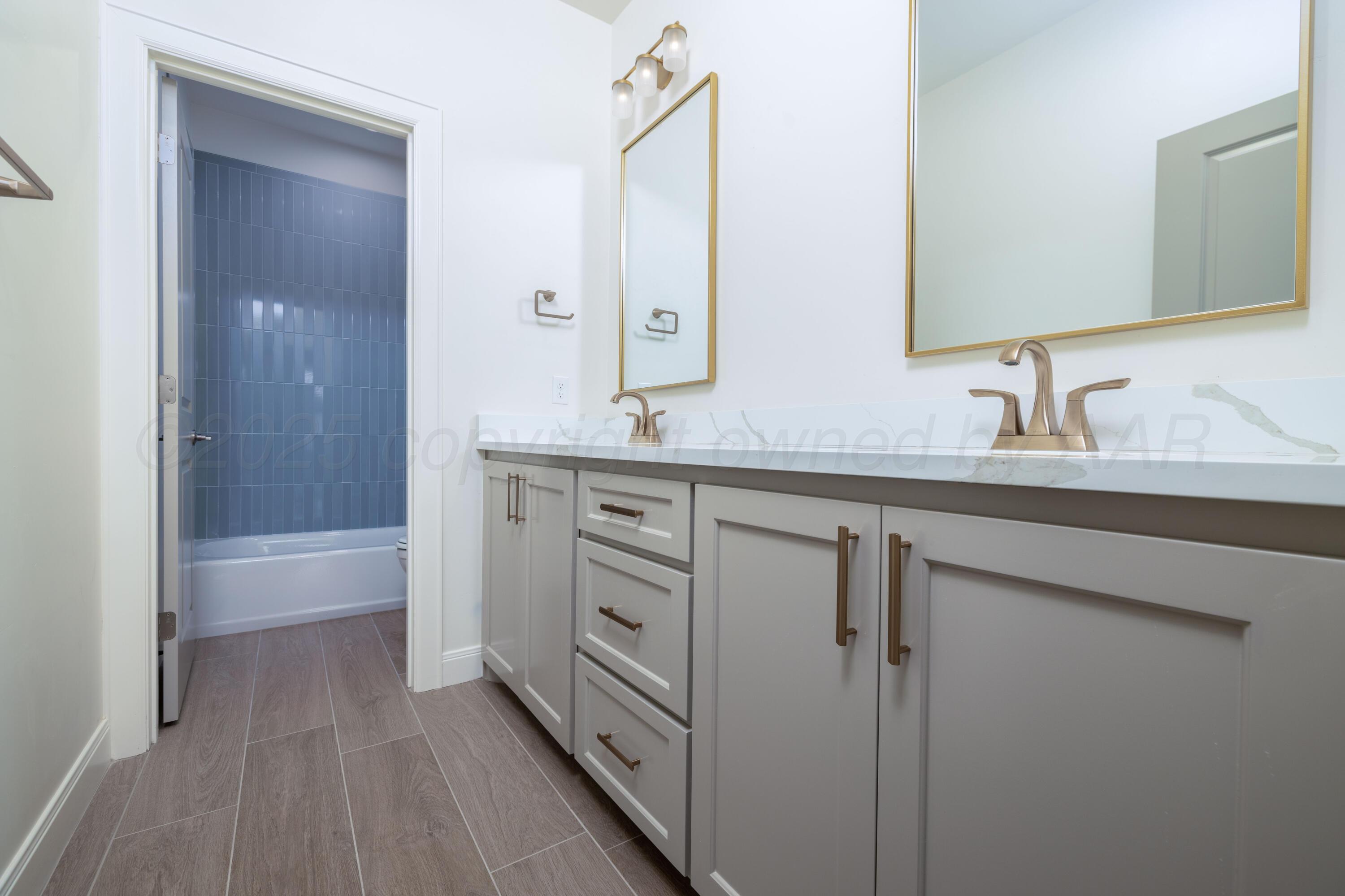 10251 Prickly Pear Road Amarillo, TX 79119 - Photo 27 of 30 a bathroom with a double vanity sink a mirror and a bathtub