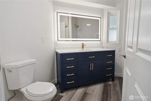 a bathroom with a toilet a sink and mirror