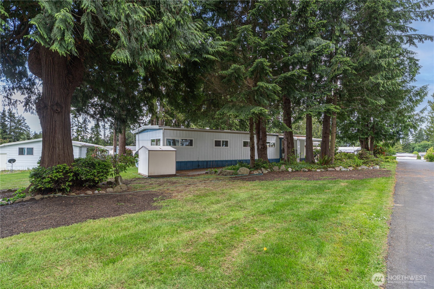 16300 Northeast State Highway, Unit 10 Poulsbo, WA 98370 - Photo 25 of 34 a view of a house with a yard and large trees