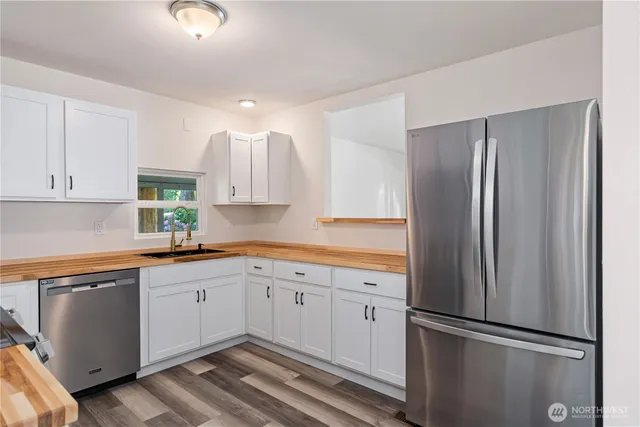 a kitchen with a refrigerator sink and cabinets