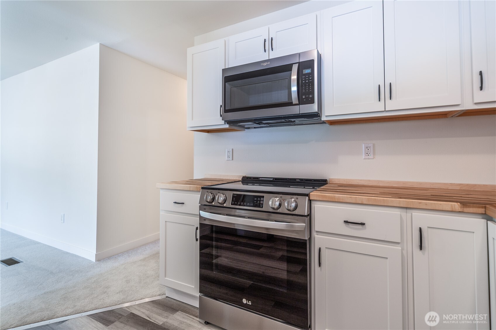 16300 Northeast State Highway, Unit 10 Poulsbo, WA 98370 - Photo 9 of 34 a kitchen with stainless steel appliances granite countertop white cabinets and a stove top oven