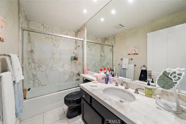 a bathroom with a sink double vanity granite tub shower and a mirror