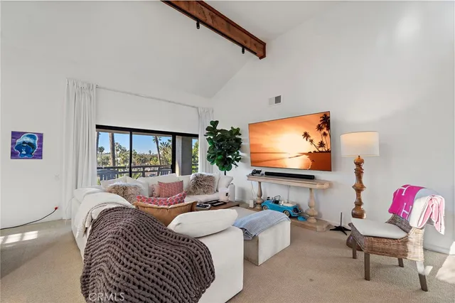 a living room with furniture a floor to ceiling window and a flat screen tv