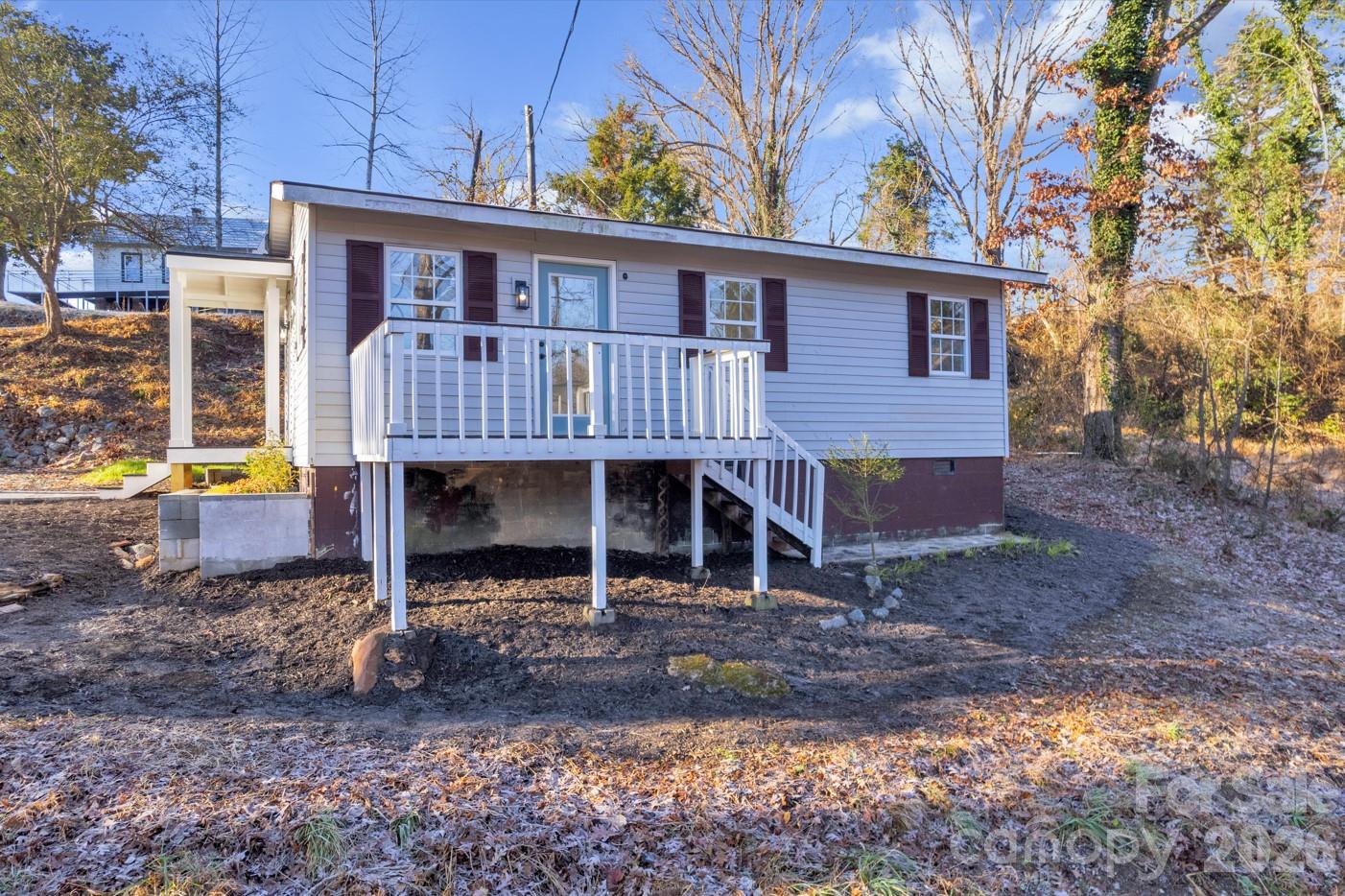 a view of a house with a yard and wooden fence
