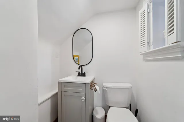 a bathroom with a toilet a sink and a mirror