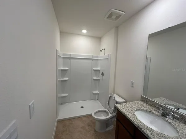 a bathroom with a granite countertop sink and a mirror