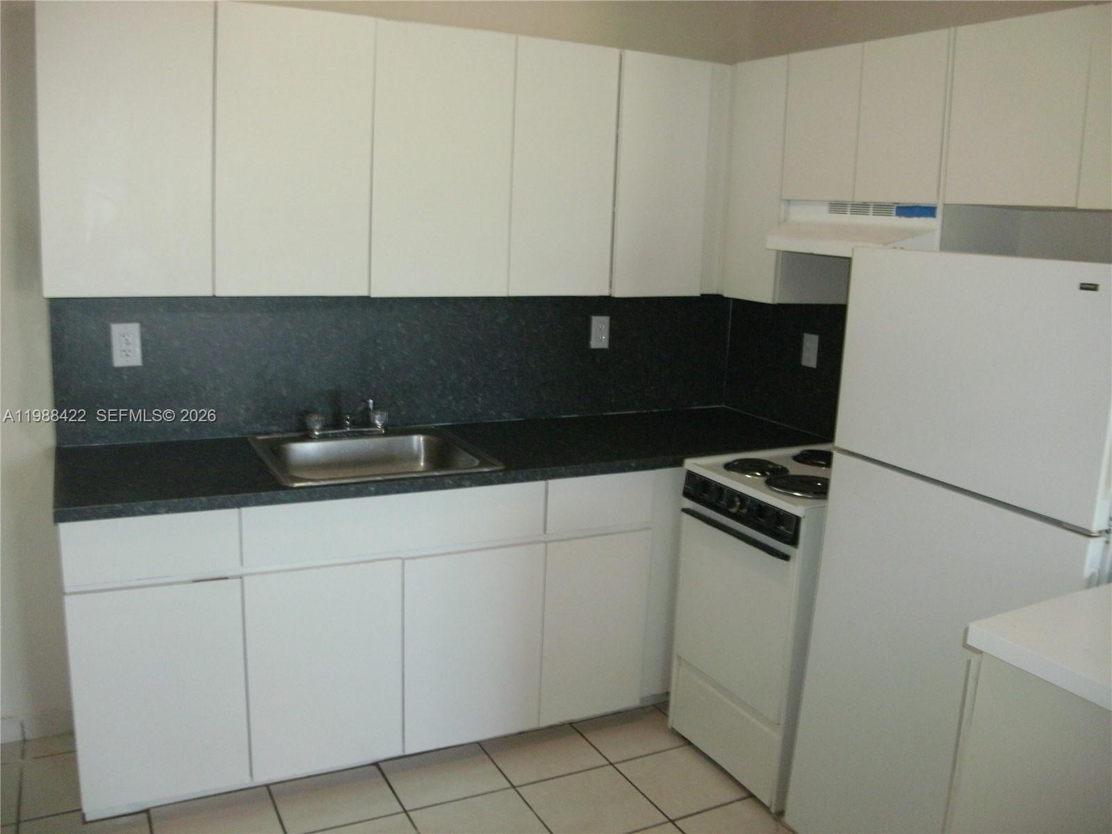 3901 Southwest 109th Avenue, Unit 6 Miami, FL 33165 - Photo 2 of 12 a kitchen with white cabinets and appliances