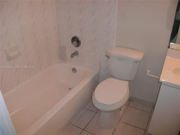 a white toilet sitting next to a bath tub