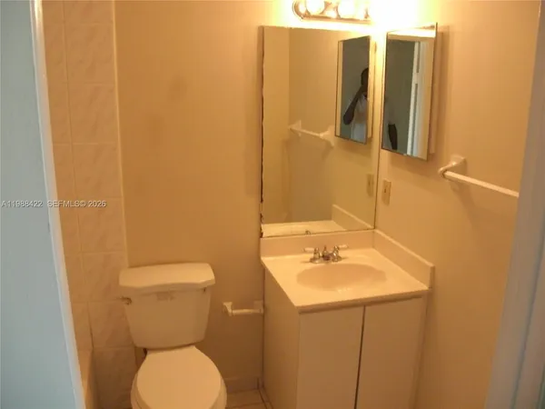 a bathroom with a sink and mirror with toilet