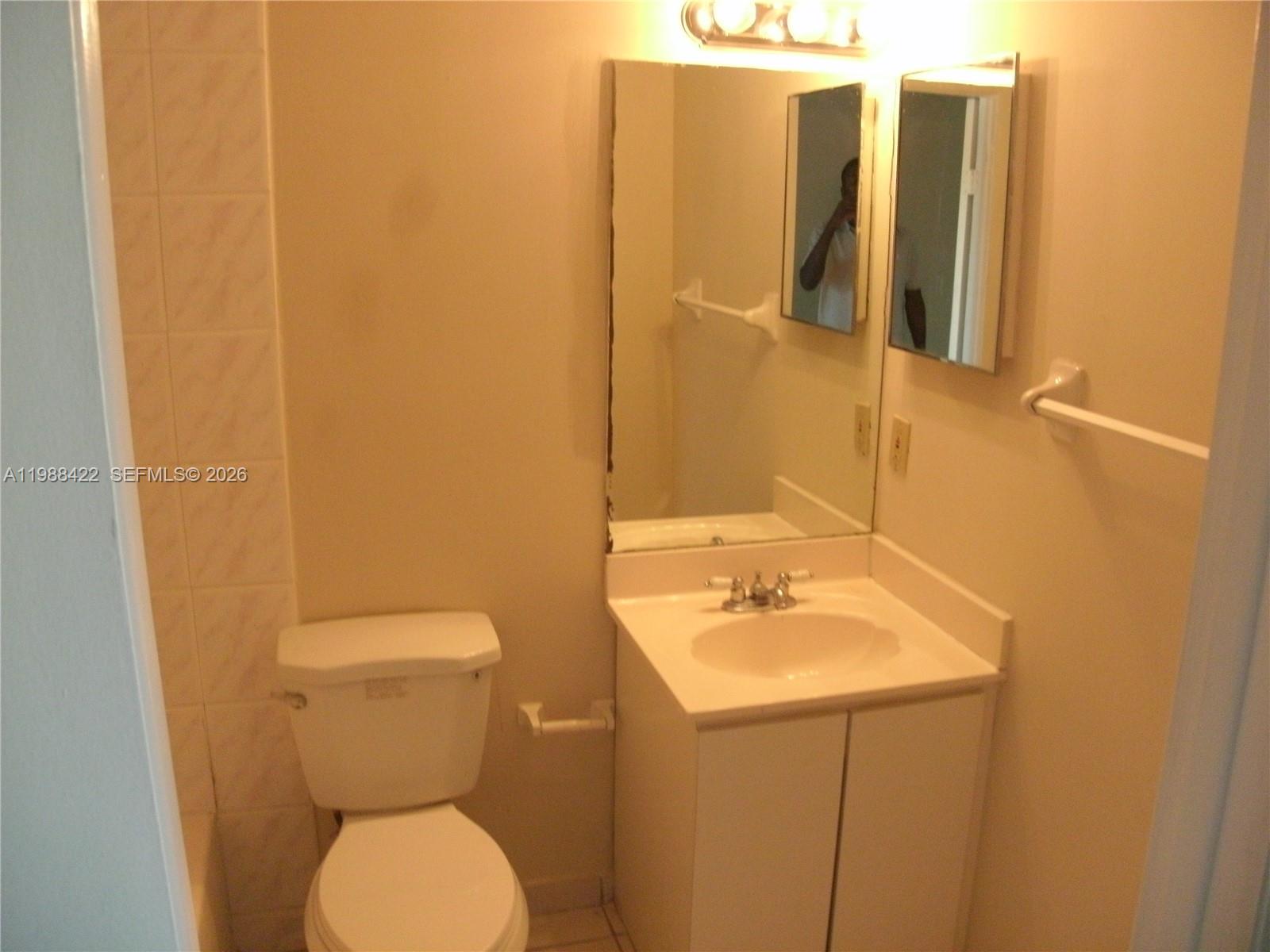3901 Southwest 109th Avenue, Unit 6 Miami, FL 33165 - Photo 6 of 12 a bathroom with a sink and mirror with toilet