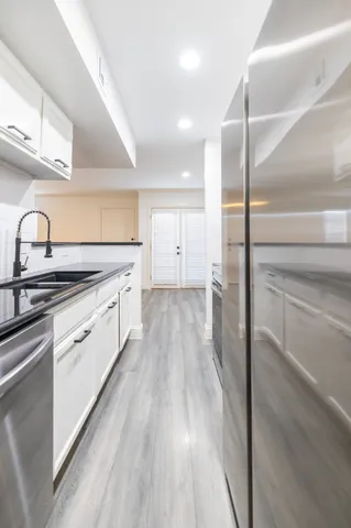 a kitchen with cabinets oven and a sink