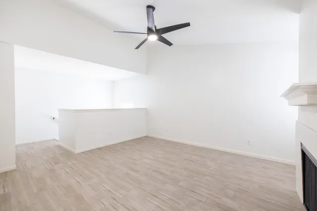 a view of a room with wooden floor and a ceiling fan