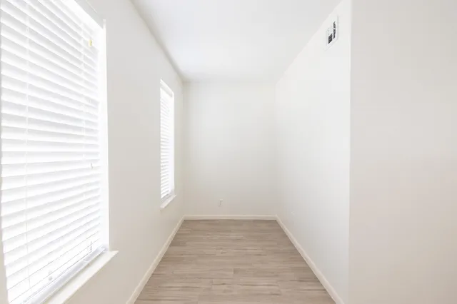 a view of a room with wooden floor and a window