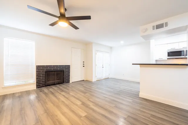 a view of empty room with wooden floor and fireplace