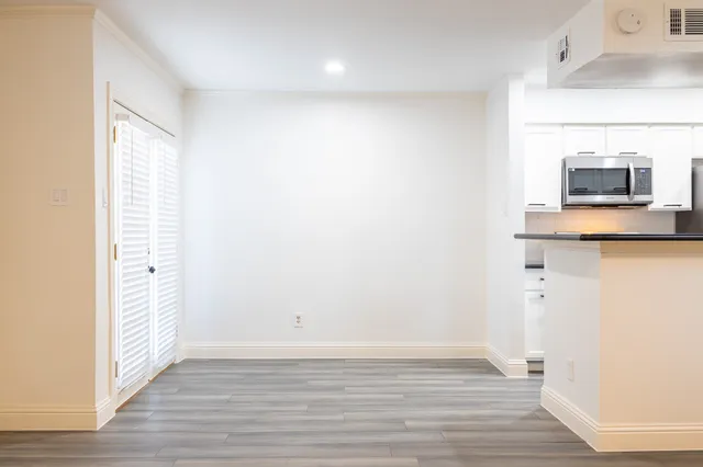 a view of a room with wooden floor and cabinet