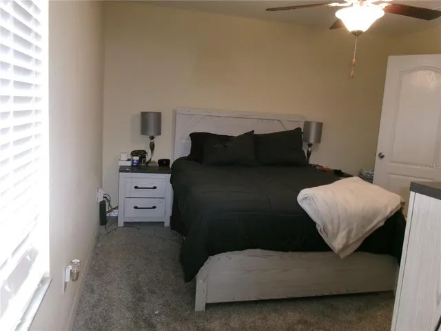 a bedroom with a bed and a flat tv screen on the dresser