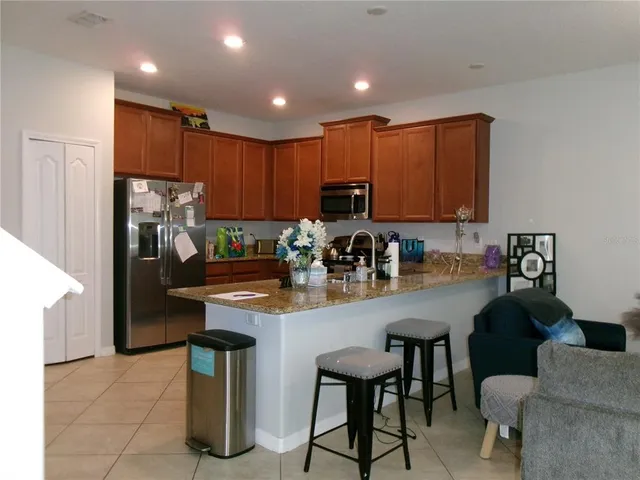 a kitchen with stainless steel appliances granite countertop a refrigerator and a stove top oven