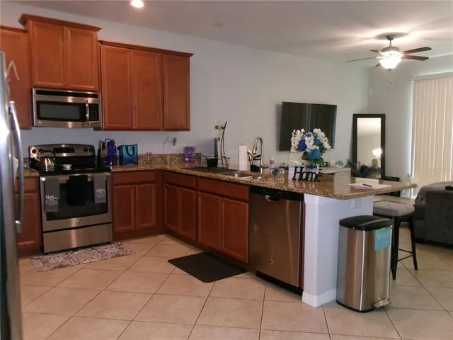 a kitchen with stainless steel appliances granite countertop a sink stove and microwave